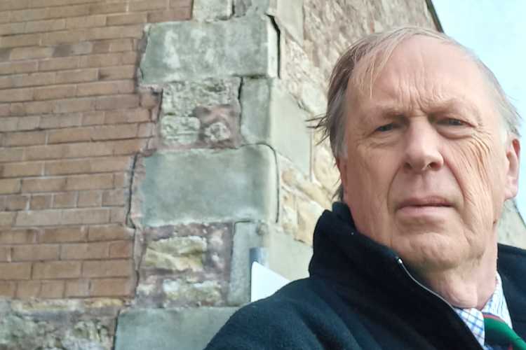 Councillor Robson beside the cracked wall