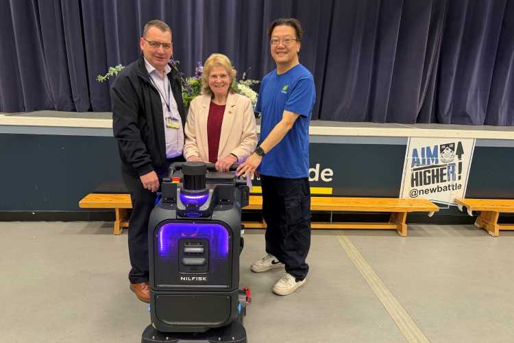 Councillor Dianne Alexander watches a demonstration of the new robotic scrubber dryer at Newbattle Community Campus with Facility Assistant Terry Suen and Facilities Manager Craig Gillie (on far left).